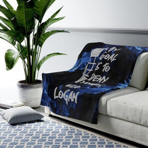 May include: A blue and black fleece blanket with a hockey stick and the text "My goal is to deny #20 Logan".