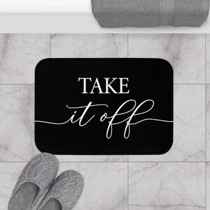May include: Black bath mat with white text that says "Take it off".