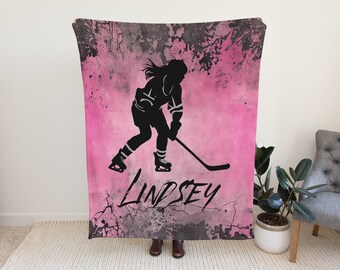 May include: Pink and black personalized throw blanket with a silhouette of a hockey player and the name Lindsey.