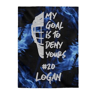 May include: A black and blue fleece blanket with a hockey mask graphic and the text "My goal is to deny yours #20 Logan".