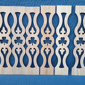 May include: Five wooden panels with a decorative cut-out design featuring a repeating pattern of shamrocks and swirls. The panels are unfinished and ready to be painted or stained.