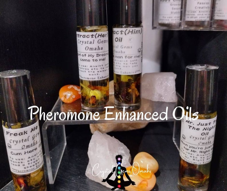 Puede incluir: Cuatro peque&ntilde;os frascos de vidrio con aplicadores de rodillo llenos de un l&iacute;quido transparente y varias hierbas y flores. Los frascos est&aacute;n etiquetados con texto que incluye "Pheromone Enhanced Oils", "Freak Me", "Cum Here", "Attract(Her)", "Act(Him)", "Mr. Just For The Night" y "Crystal Gems Omaha".