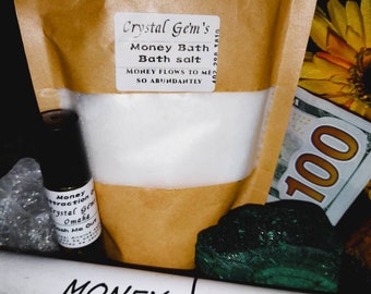 Puede incluir: Una bolsa de papel marrón con sales de baño blancas en su interior. La bolsa tiene una etiqueta que dice "Crystal Gem's Money Bath Bath Salt" y "MONEY FLOWS TO ME SO ABUNDANTLY". También hay cristales verdes y transparentes, una pequeña botella de aceite y un tubo blanco con la palabra "MONEY" en él.