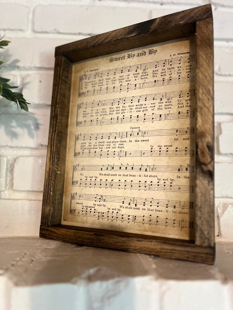 Puede incluir: Una impresi&oacute;n de partitura vintage enmarcada con el t&iacute;tulo "Sweet By and By" y letras de la canci&oacute;n. La partitura est&aacute; impresa en papel envejecido con un fondo marr&oacute;n y notas musicales negras.