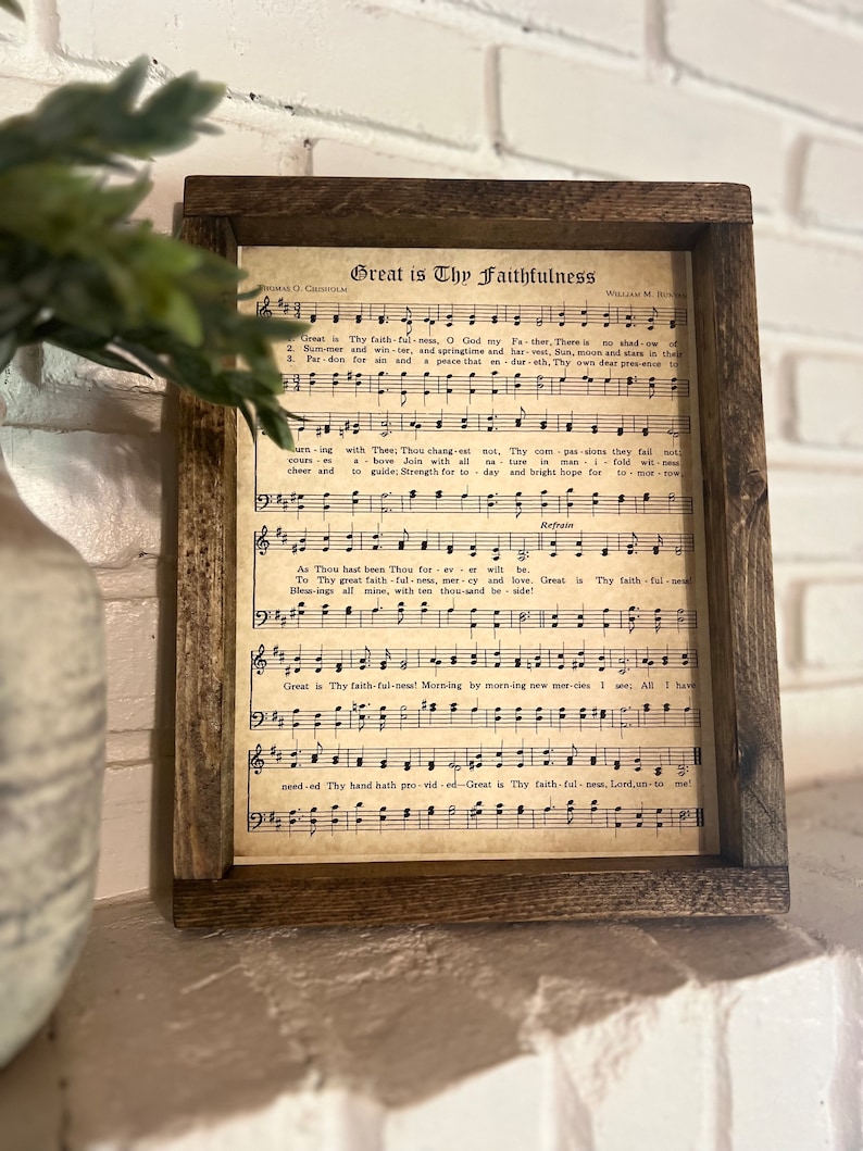 K&ouml;nnte beinhalten: Ein gerahmter Druck eines alten Kirchenliedblattes mit dem Titel "Great is Thy Faithfulness". Die Noten sind auf gealtertem Papier mit schwarzer Tinte gedruckt und zeigen Noten und Text.