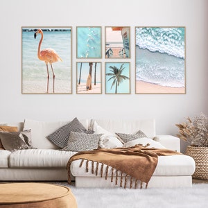 May include: A collage of six framed photographs featuring beach scenes. The top left photo shows a pink flamingo standing in shallow water. The top middle photo shows a group of people paddleboarding in turquoise water. The top right photo shows a view of a beach with a lifeguard stand. The bottom left photo shows a surfboard leaning against a palm tree. The bottom middle photo shows a palm tree with blue sky in the background. The bottom right photo shows a close-up of ocean waves crashing on a sandy beach.