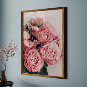 Puede incluir: Una impresi&oacute;n enmarcada de un ramo de rosas rosas. Las rosas est&aacute;n dispuestas en un racimo y llenan el marco. El fondo es de un blanco suave.