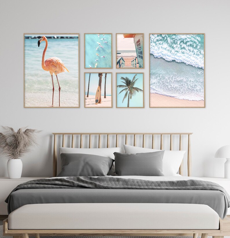 May include: A set of six framed prints featuring beach scenes. The prints include a pink flamingo standing in the water, a palm tree, a surfboard, a view of the ocean from above, a view of the ocean from the beach, and a view of a boardwalk leading to the beach.