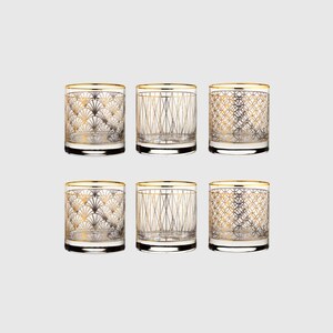 Puede incluir: Un juego de seis vasos de cristal transparente con patrones geom&eacute;tricos dorados. Cada vaso tiene un borde dorado y un dise&ntilde;o distintivo, incluyendo motivos en forma de abanico, l&iacute;neas verticales que se cruzan y patrones de rejilla circular.