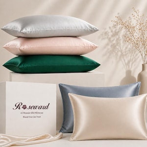 May include: A selection of silk pillowcases in various colours: silver, blush pink, and emerald green stacked, with light blue and cream pillowcases below. The box displays the text "Roseward 22 Momme Silk Pillowcase Brand You Can Trust".