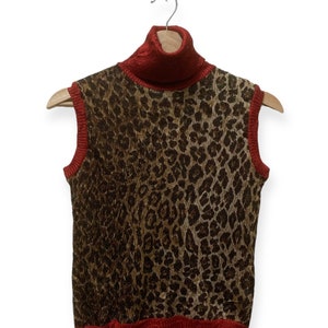 May include: A sleeveless turtleneck sweater with a leopard print pattern and red trim.