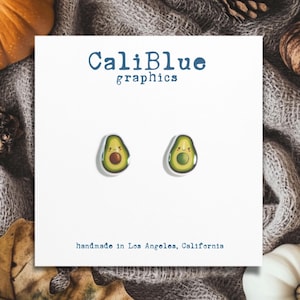 May include: A pair of avocado-shaped earrings with a cute face. The earrings are handmade in Los Angeles, California. CaliBlue graphics.