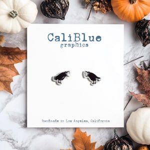 May include: A pair of black crow earrings on a white card with the text "CaliBlue graphics" and "handmade in Los Angeles, California".