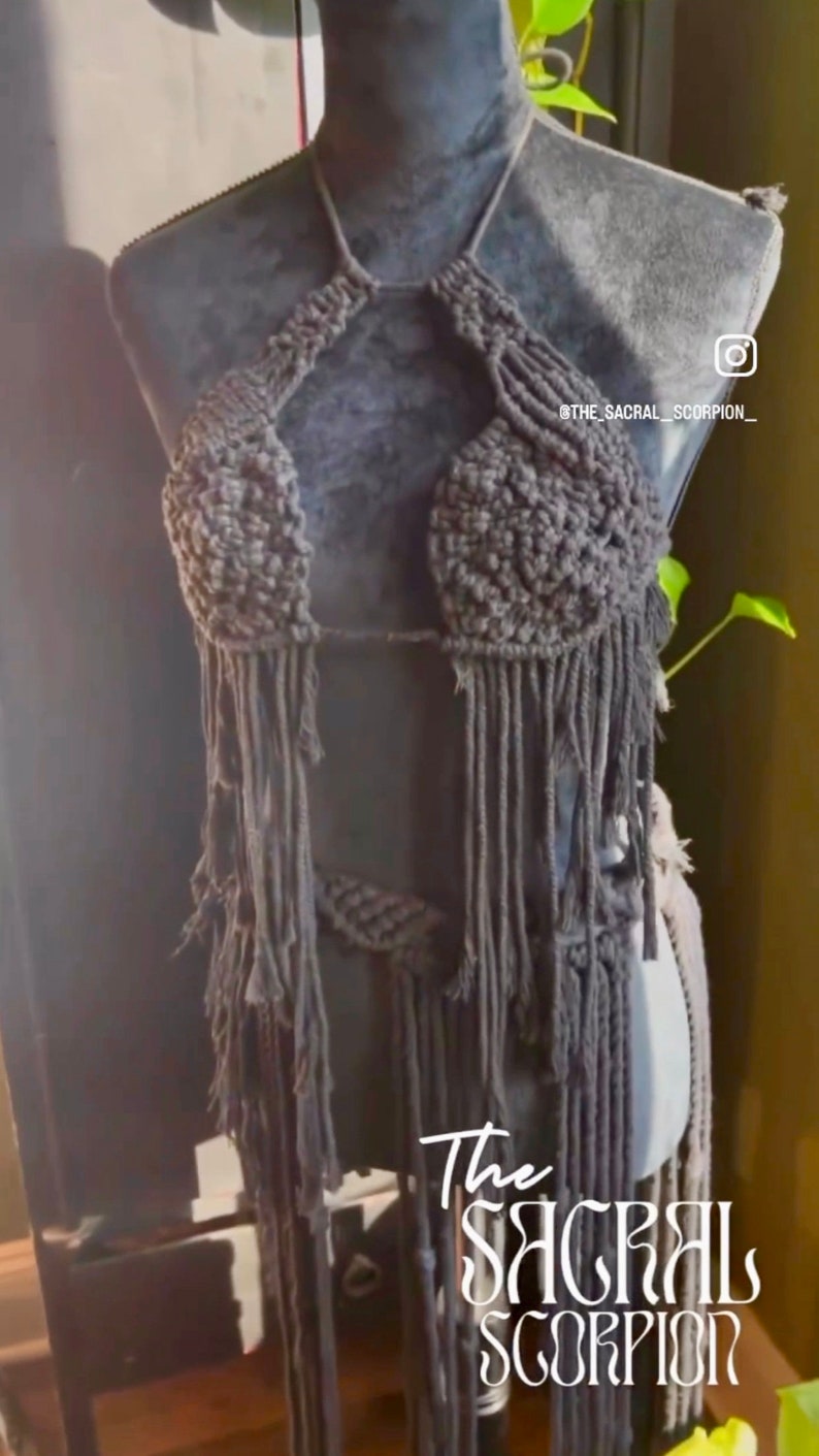 Op de afbeelding: Een grijs geh&auml;keld haltertop met franjes. Het topje wordt getoond op een mannequin. De tekst "The Sacral Scorpion" is zichtbaar in de rechterbenedenhoek van de afbeelding.