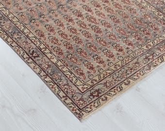 May include: A rectangular area rug featuring a repeating pattern of small, stylized floral motifs in shades of red, black, and cream. The rug has a wide, decorative border with intricate geometric and floral designs in matching colors.