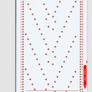 May include: A white pegboard with a pattern of holes in a heart shape. The pegboard is numbered from 1 to 35 on the right side.