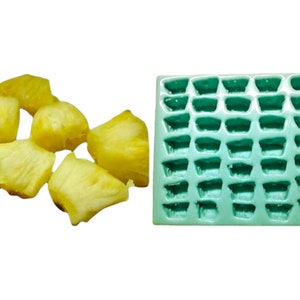 May include: A green silicone mold with 36 individual cavities shaped like pineapple chunks.  There are six rows of six cavities.  Next to the mold are six yellow pineapple chunks.