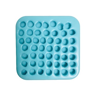 Pu&ograve; includere: Uno stampo in silicone quadrato di colore azzurro con una griglia di quarantanove piccole cavit&agrave; circolari disposte in sette file e sette colonne, progettato per la creazione di forme sferiche uniformi o piccoli oggetti decorativi.