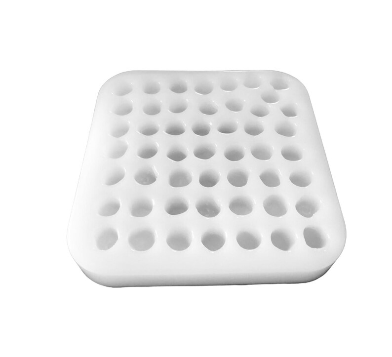 Pu&ograve; includere: Uno stampo rettangolare in silicone bianco con una griglia di trentasei cavit&agrave; circolari disposte in sei file e sei colonne. Lo stampo presenta angoli arrotondati e una superficie opaca liscia, progettato per la colata di piccoli oggetti.
