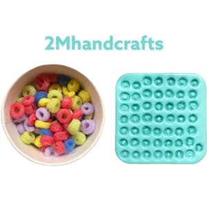 May include: A blue silicone mold with 49 round cavities, perfect for making small candies or chocolates. A bowl of colorful cereal is shown in the background.