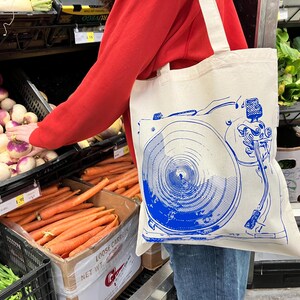 https://www.etsy.com/listing/1805262270/gift-for-record-collector-vinyl-music

record tote bag
vinyl lover gift
dj gift idea
music tote bag
screenprinted tote
musician gift
vinyl record bag
music fan tote
canvas tote for records
record store shopper
hand printed tote
cool music gifts
turntable tote bag