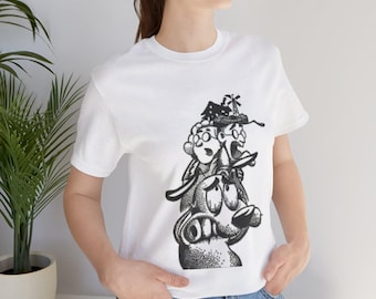 May include: White t-shirt with a black and white illustration of a dog with a person on its head. The illustration is stylized and has a cartoonish look.