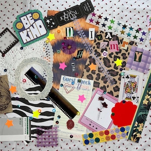 May include: A collage of decorative paper ephemera, including a doily, film strips, and a "Be Kind" sticker. Other elements include a playing card, a guest check, and various stickers and embellishments. The color palette is diverse, with pink, yellow, and green accents.