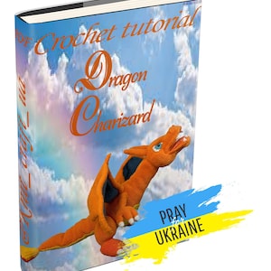 May include: A crochet tutorial book cover featuring a crocheted orange dragon with black wings against a blue sky with white clouds. The title of the book is "Crochet tutorial Dragon Charizard". The text "PRAY for UKRAINE" is in a yellow and blue banner in the lower right corner.