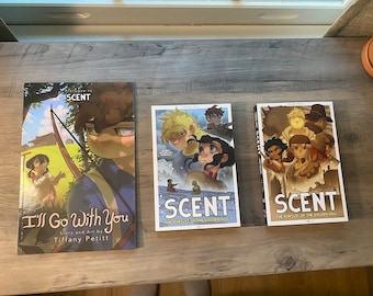 May include: Three graphic novels with the title "SCENT" on the cover. The first novel is titled "Prologue to Scent" and features a young boy with a bow and arrow. The second novel is titled "The Pursuit of the Golden Will" and features a group of people in a snowy landscape. The third novel is titled "The Pursuit of the Golden Will" and features a group of people in a forest setting.