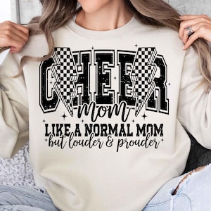 May include: A white sweatshirt with black text that reads "Cheer mom like a normal mom but louder & prouder". The text is surrounded by black and white checkered flags.