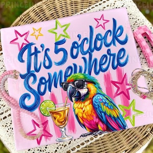 May include: Pink t-shirt with the phrase "It's 5 o'clock Somewhere" in blue script, featuring a colorful parrot wearing sunglasses and holding a cocktail. The design includes star accents.