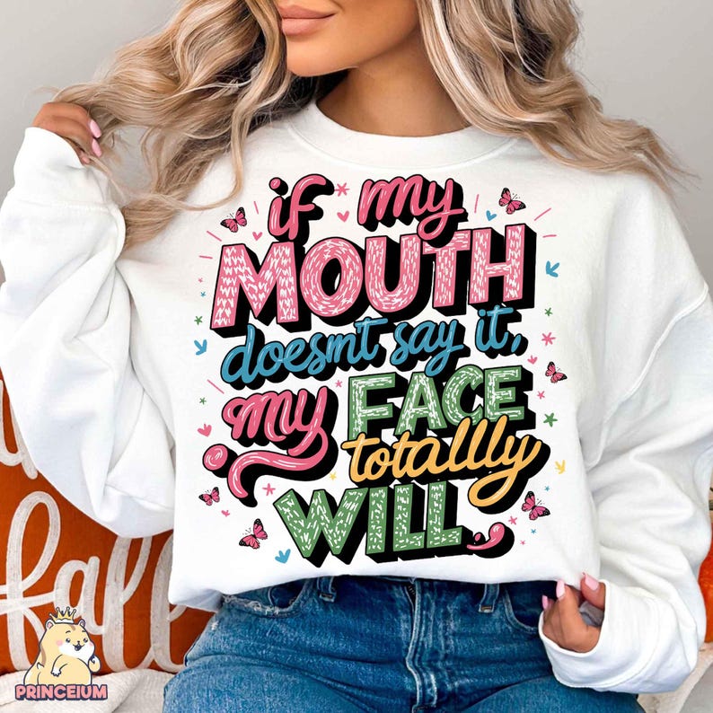 May include: White sweatshirt with a colorful graphic that says "If my mouth doesn't say it, my face totally will."