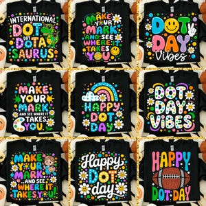 May include: Nine black t-shirts with colorful graphic designs. The designs include phrases like "International Dot Day," "Make Your Mark," and "Happy Dot Day." Some designs feature dinosaurs, smiley faces, rainbows, and a football.