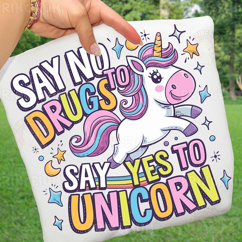 May include: White pillow with a cartoon unicorn design. The unicorn has a yellow horn, pink nose, and a colorful mane and tail. Text on the pillow reads "SAY NO TO DRUGS SAY YES TO UNICORN" in various colors and fonts.