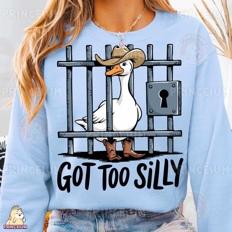 May include: A light blue sweatshirt with a white goose wearing a cowboy hat and boots behind bars. The text "GOT TOO SILLY" is printed below the image.