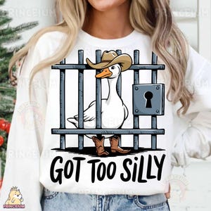 May include: White sweatshirt with a cartoon illustration of a goose wearing a cowboy hat and boots, behind bars. The text "GOT TOO SILLY" is printed below the image.