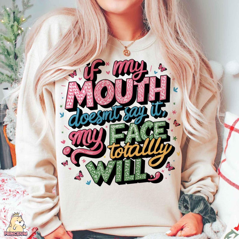 May include: A cream-colored sweatshirt with a colorful graphic that reads "If my mouth doesn't say it, my face totally will."
