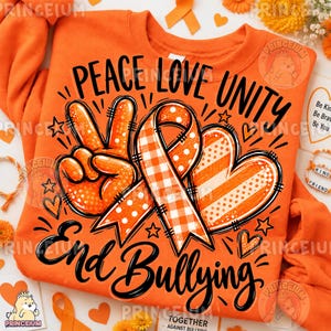 May include: An orange sweatshirt featuring a black graphic design with the text PEACE LOVE UNITY and End Bullying. The design includes a hand making a peace sign, a ribbon with a checkered pattern, a heart with stripes, and small stars.