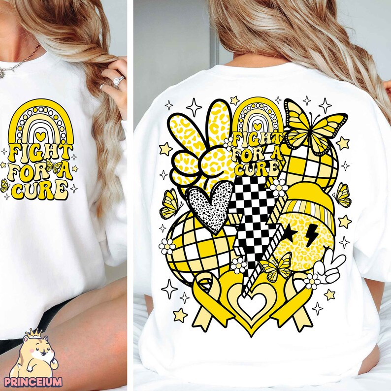 May include: White sweatshirt with a yellow and black graphic design featuring a rainbow, hearts, peace signs, butterflies, and the text "Fight for a Cure".