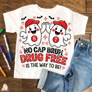 May include: A white short-sleeve t-shirt featuring two cartoon ghosts wearing red baseball caps, high-fiving, with the text "NO CAP BRUH, DRUG FREE IS THE WAY TO BE!" The ghosts have red circles on their chests with the numbers 6 and 7 inside.