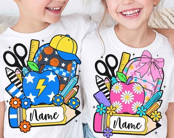 May include: Two white t-shirts featuring school-themed graphic prints. The left shirt shows a blue apple with a yellow lightning bolt, a basketball-patterned backpack, and a pencil with the text Name. The right shirt shows a pink daisy-patterned apple, a pink backpack with a bow, and a pencil with the text Name.