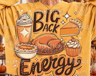 May include: A mustard yellow sweatshirt featuring a graphic print with the text BIG BACK ENERGY. The design includes illustrations of a whipped cream topped drink, a slice of pumpkin pie, a roasted turkey, and a cupcake with a cherry.
