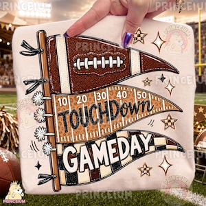 May include: A light-coloured sweatshirt featuring a graphic of three pennants attached to a wooden pole. The top pennant is brown with a football, the middle is tan with leopard print and yard lines, and the bottom has a black and white checkerboard.