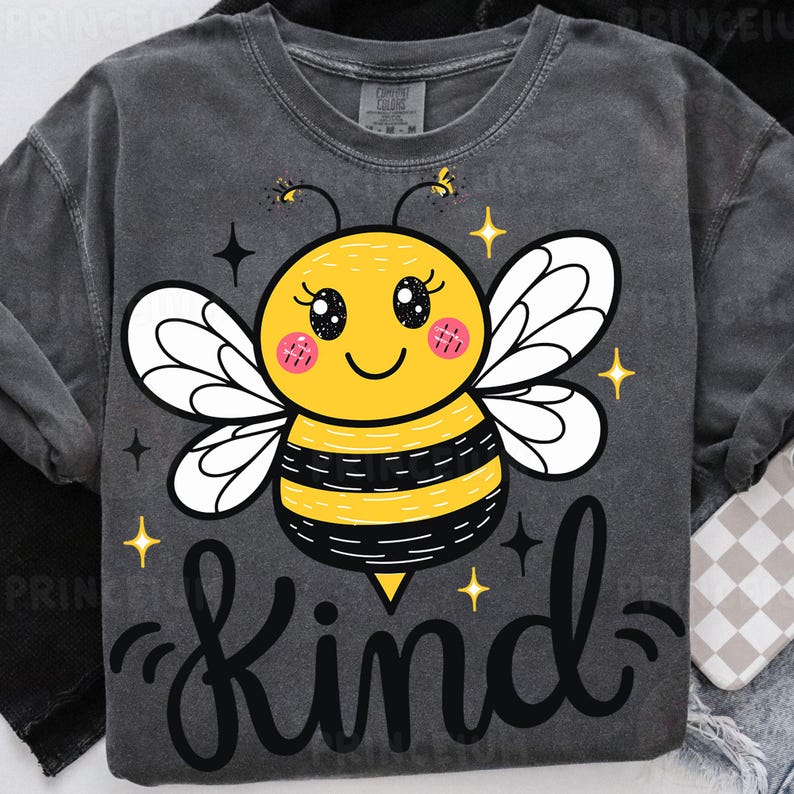 May include: Dark gray sweatshirt featuring a cartoon bee with a yellow body, black stripes, and white wings. The bee has a smiling face and the word "Kind" in a script font below. Sparkle accents are around the bee.