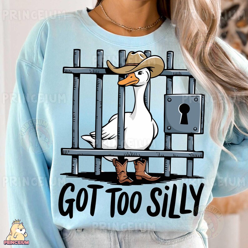 May include: A light blue sweatshirt with a cartoon image of a goose wearing a cowboy hat and boots. The goose is behind bars and the text "GOT TOO SILLY" is printed below the image.