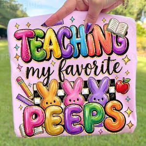 May include: A light pink t-shirt with the words "TEACHING my favorite PEEPS" in colorful bubble letters. The design includes cartoon bunnies, a pencil, a book, an apple, and stars.