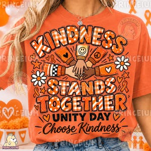 Może przedstawiać: Pomarańczowy t-shirt z grafiką i napisem KINDNESS STANDS TOGETHER UNITY DAY Choose Kindness. Wzór zawiera ilustracje ułożonych na sobie dłoni, otoczonych pomarańczowo-białymi literami w kratkę, kwiatami oraz sercami.