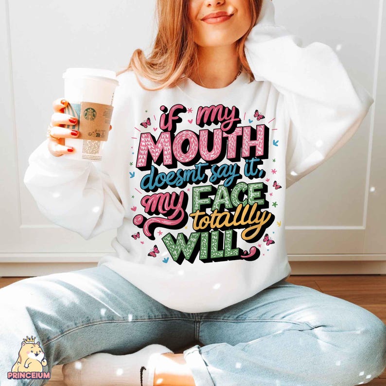 May include: White sweatshirt with a colorful graphic that says "If my mouth doesn't say it, my face totally will."