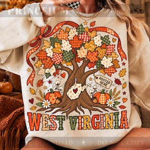 Puede incluir: Una sudadera color crema con un gráfico grande de un árbol con hojas de otoño estampadas, calabazas y un mapa de Virginia Occidental con un corazón. El texto dice ROOTED HERE y WEST VIRGINIA en una fuente a cuadros de color naranja y verde.