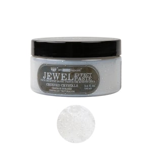 May include: A round jar of light blue Jewel Effect Paste with a black lid. The label reads Art Extravagance Jewel Effect Paste Crushed Crystals 3.4 fl. oz. Below the jar is a circular swatch of the translucent paste containing small silver glitter.